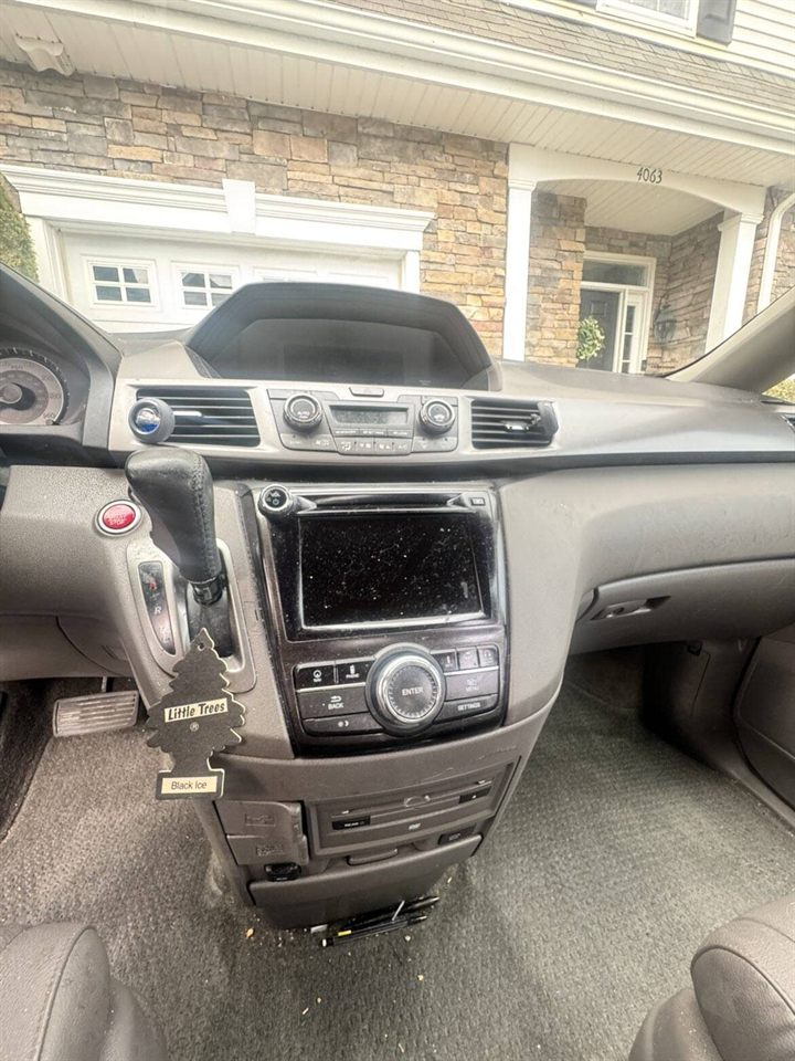 Dashboard and center console before detailing — dust and grime on surfaces and screen