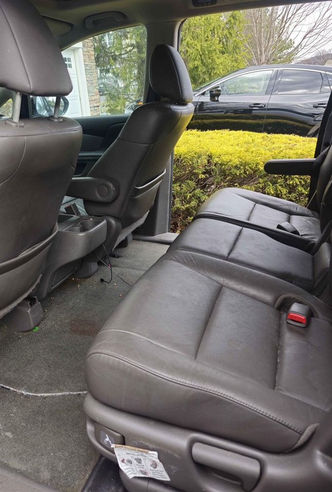 Second-row seats and floor before detailing — stained carpet and debris
