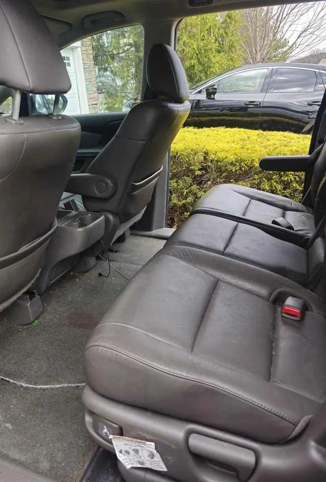 Second-row seats and floor before detailing — stained carpet and debris