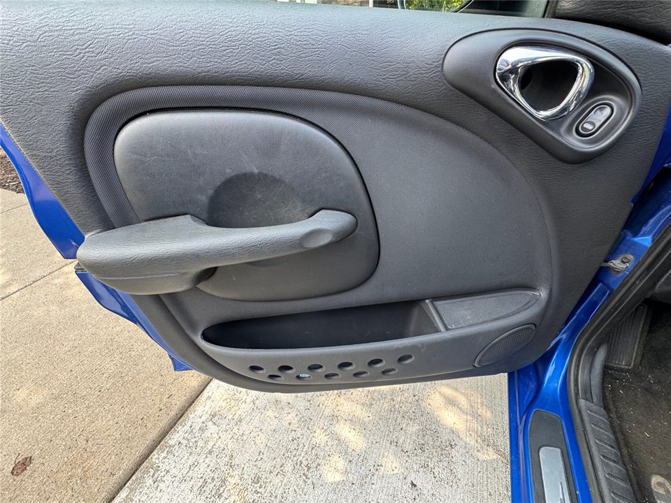 Driver door panel before detailing — dust and scuffs on the armrest and pockets