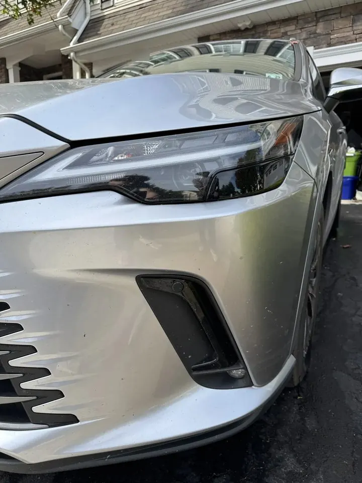 Lexus headlight and bumper before detailing — bug spots and grime on the paint